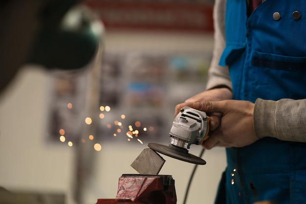 Worker working with a circular grinder on a metal with sparks