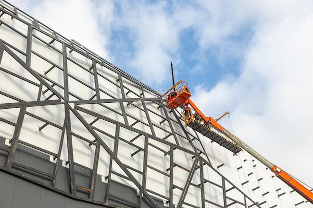 Workers on the aerial work platform at facade installation\
work