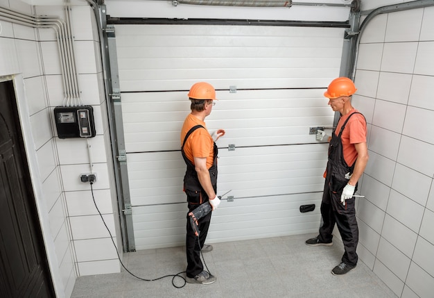 The workers are installing lift gates in the garage.