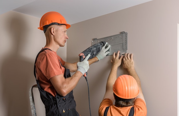 Workers are installing a split system for a home air conditioning system.