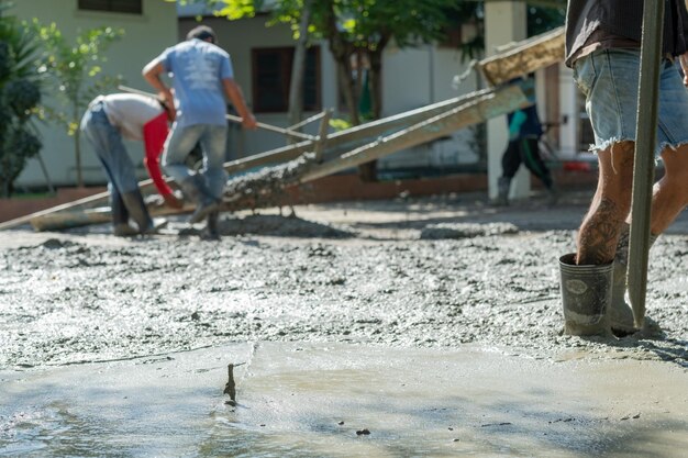 Workers are pouring concrete and equipment