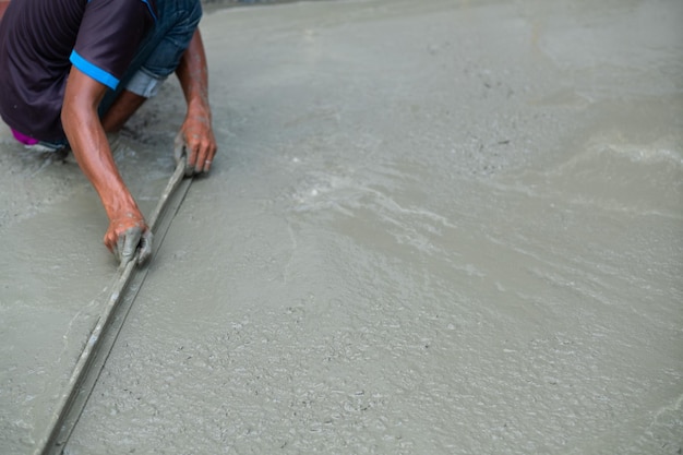 Workers are pouring concrete and equipment