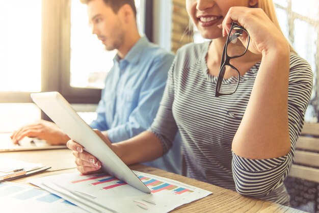 Workers are using gadgets and smiling while working