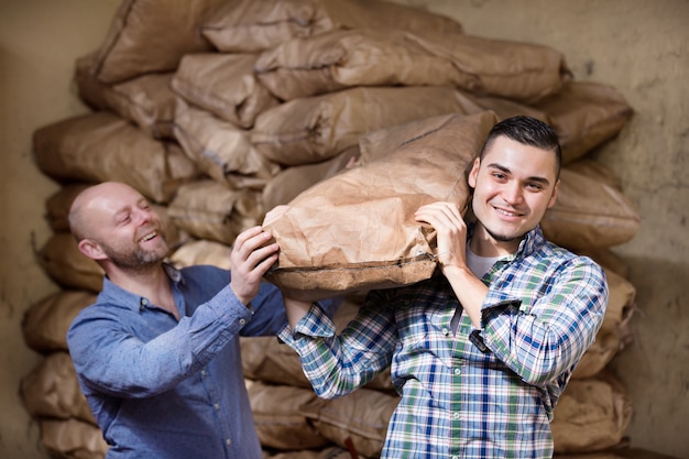 Workers carrying bags of cement 