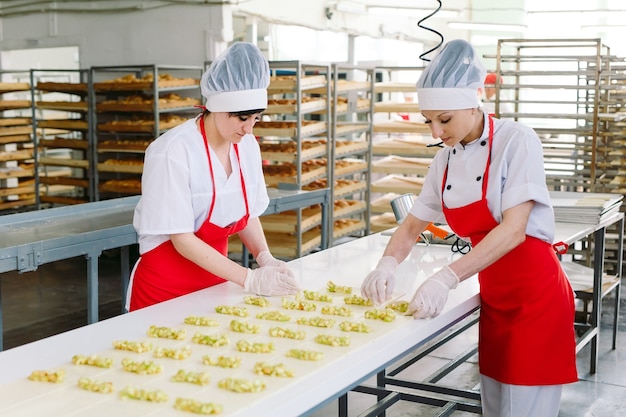 Workers of the confectionery factory prepare desserts with filling