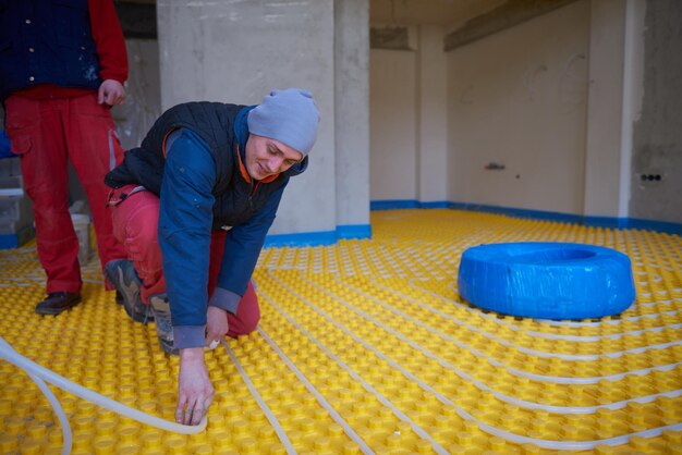 workers installing underfloor heating system