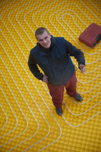 Photo workers installing underfloor heating system