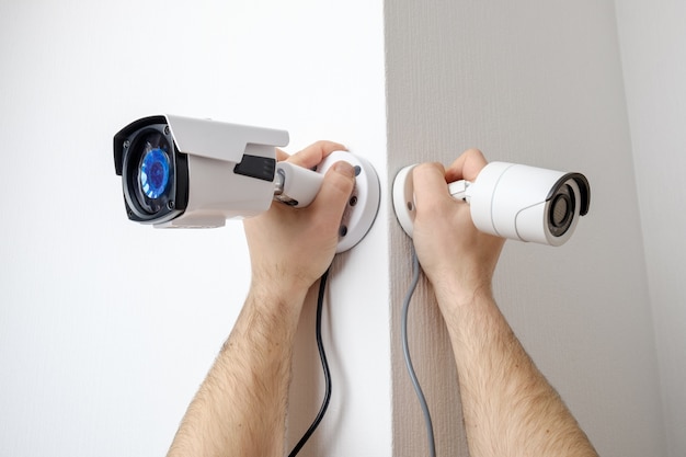 Photo workers installing video surveillance cameras on walls