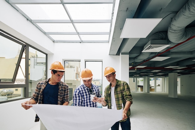 Workers Looking At Construction Plan