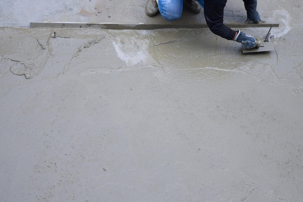 Workers plastering ready mixed concrete floor at the construction agencyx9