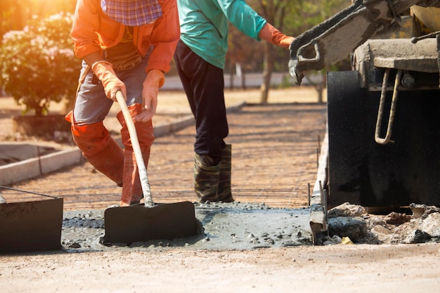 Workers pouring concrete with a cement mixer truck