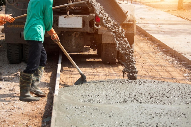 Workers pouring concrete with a cement mixer truck