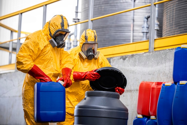 危険物や酸を扱う化学防護服とガスマスクの労働者