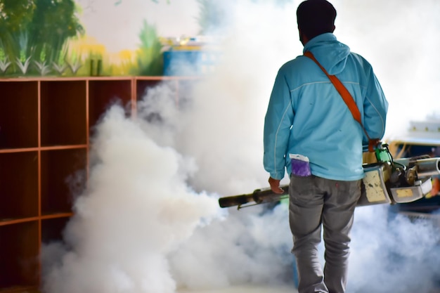 Workers spray mosquito pesticides with a motorized sprayerxA