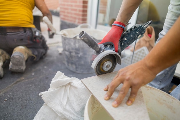 workers tiling house cutting floor tiles terrace