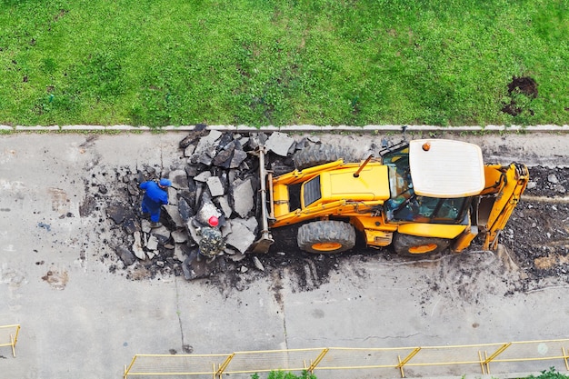 Photo workers and tractor remove asphalt