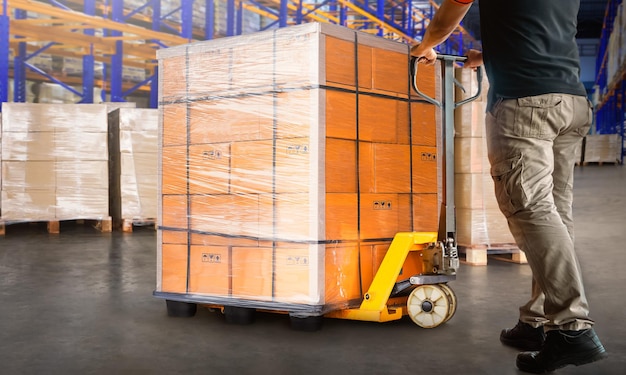 Photo workers unloading package boxes on pallets in warehouse distribution supplies warehouse shipping