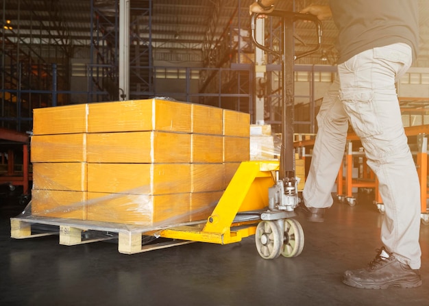 Foto lavoratori che scaricano scatole di imballaggio su pallet in magazzino magazzino di forniture per scatole di spedizione