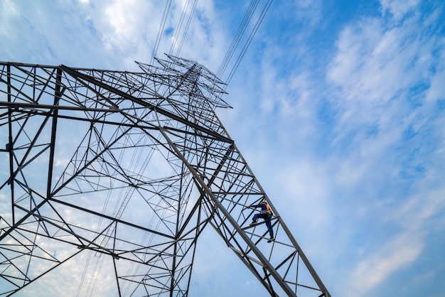 Workers wearing safety harnesses are working at high voltage pylons for inspection and maintenance at high voltage pylon stations