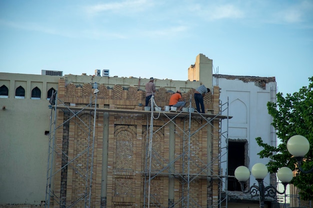 Workers working on building old style building