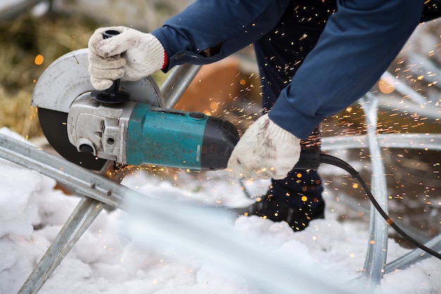 Photo working angle grinder in the hands of a worker