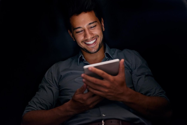 Working around the clock to meet his deadlines Cropped shot of a young businessman working late on a digital tablet