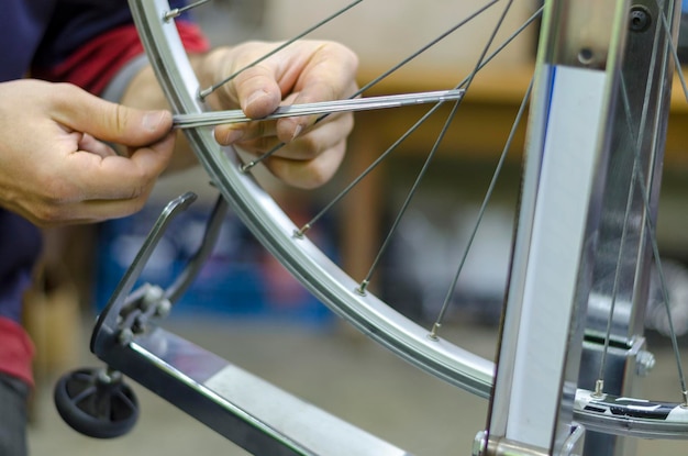 Working in a biking repair shop bicycle wheel repair to hold in hand spokes