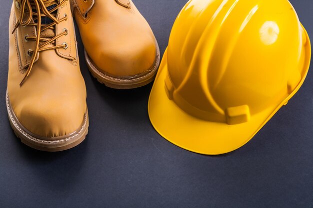 Working boots and helmet on black background