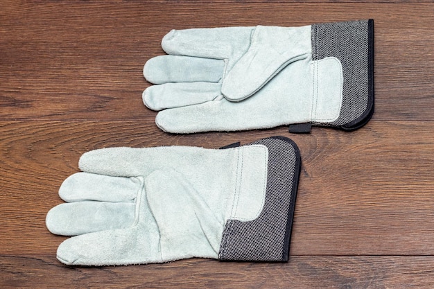 Working construction mittens made of dense fabric on a wooden background