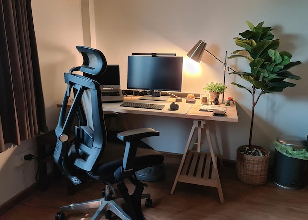 Angolo di lavoro con monitor portatile scrivania in legno sedia ergonomica e decorare oggetto