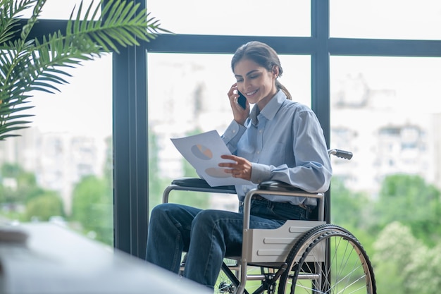 일하는 날. 전화 통화를 하는 장애인 젊은 여성