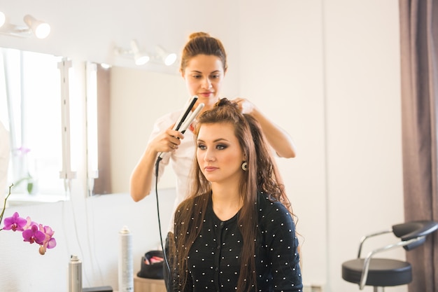 Giornata di lavoro all'interno del salone di bellezza. il parrucchiere fa lo styling dei capelli.