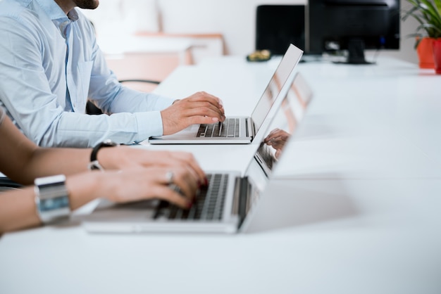 Working day in office. Businesspeople's hands typing on laptop keyboard in the office.