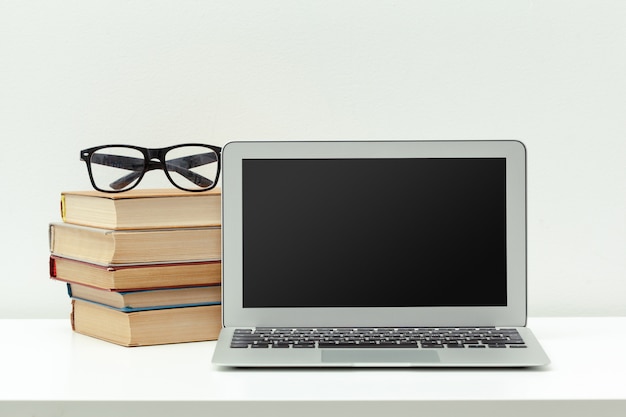 Working desk.Open laptop, books and other office supply