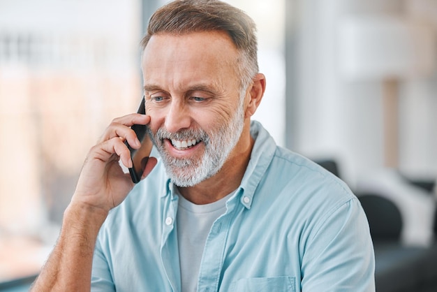 Lavorare da casa non è mai stato così facile inquadratura di un uomo d'affari maturo seduto da solo nel suo ufficio a casa e usando il suo cellulare