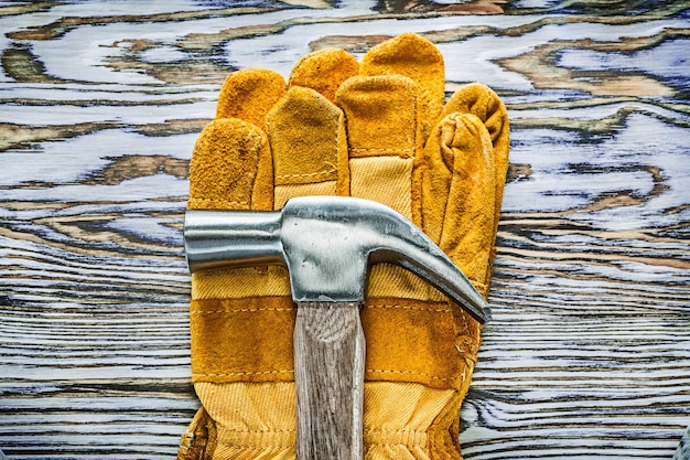 Working gloves claw hammer on wooden board