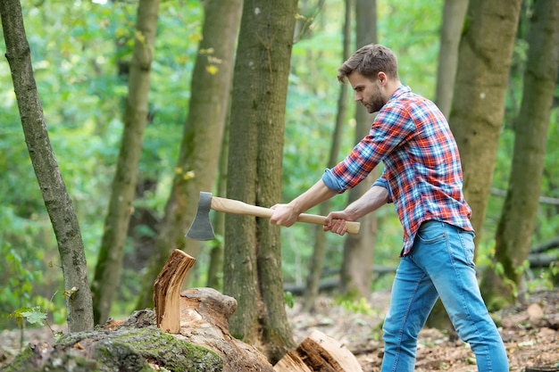 Working hard. firewood at the campsite. camping and hiking. outdoor activity. strong man with ax. woodcutter. ranch man carry axe. sexy guy wear shirt in forest. male power and energy.