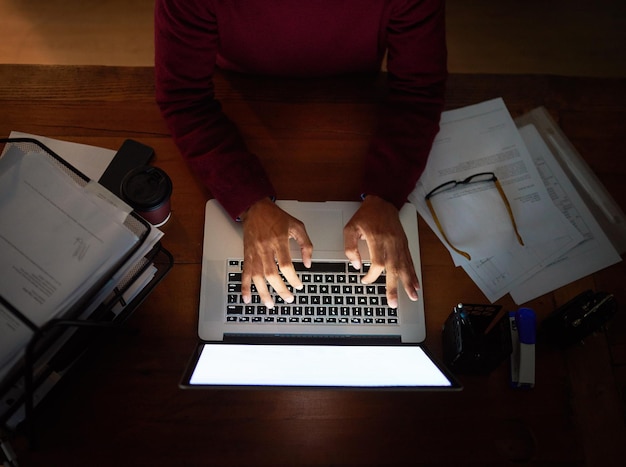 Photo working hard to meet the project deadline high angle shot of an unrecognizable man working late in the office