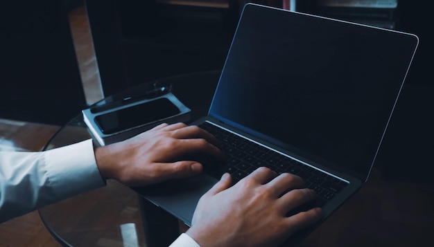 Lavorando sul computer portatile con l'immagine di concetto del primo piano dello schermo in bianco