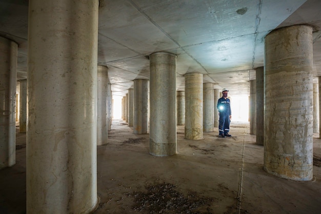 Working male inspection pole underground of tank equipment tunnel By using the flashlight inside under tank.