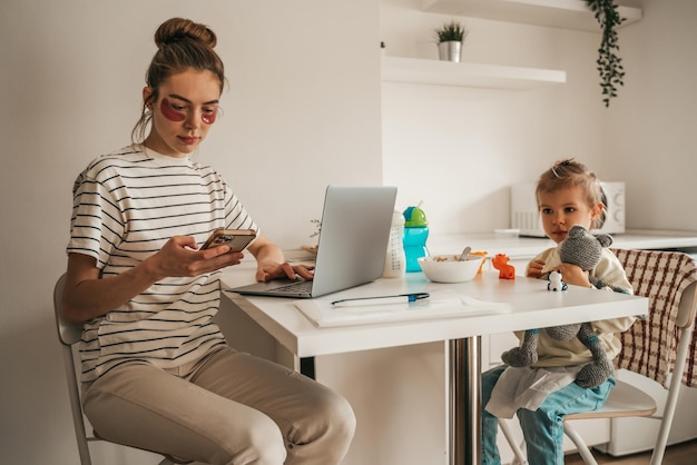 Photo working mom and playing daughter in the kitchen