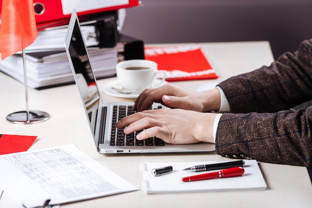 Working in office male hands using a laptop