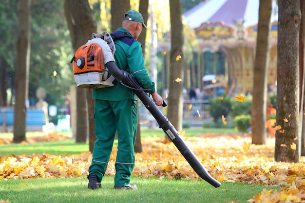 Working in the Park removes leaves with a blower