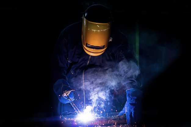 Working person About welder steel Using electric welding machine.