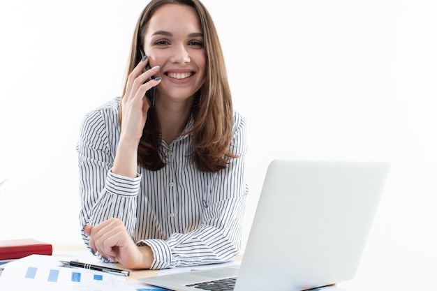 Working process in the office. Girl talking on the phone in the workplace