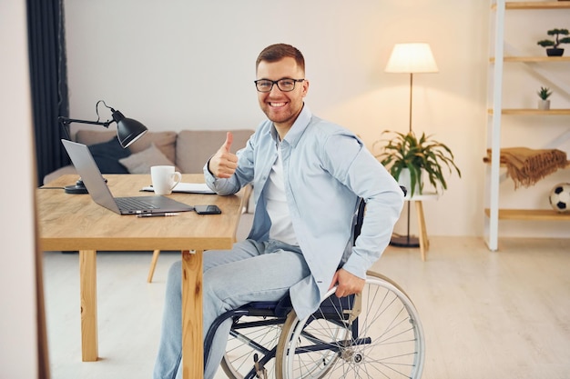 Photo working on a project from home disabled man in wheelchair