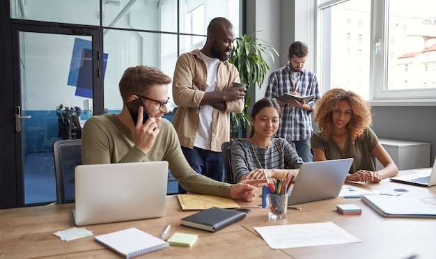 Lavorando al progetto insieme gruppo di colleghi multirazziali che comunicano parlando condividendo fresco