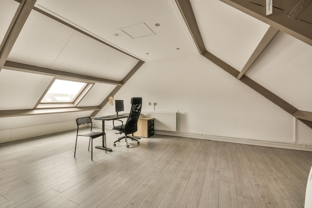 A working space in the attic of the house with a computer near to the window