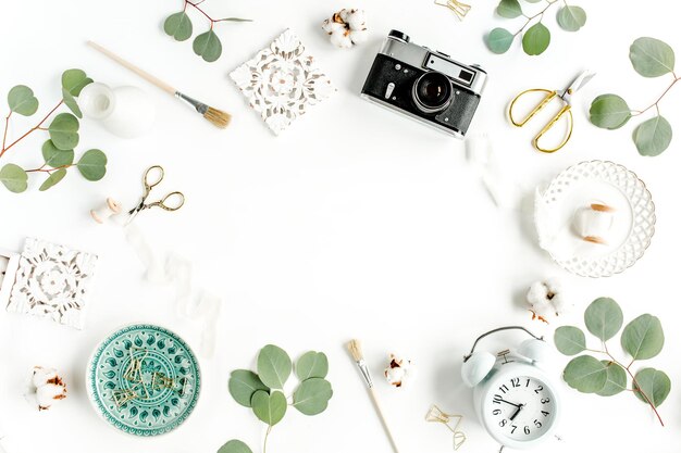 Photo working space with ceramic sheet monstera retro camera eucalyptus leaf accessories on white