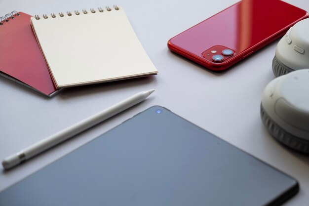 Foto tavolo di lavoro a casa smartphone notepad cuffie tablet e stylus dispositivi elettronici moderni